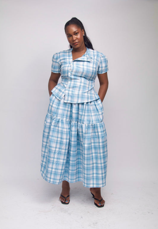 Woman wearing a blue plaid dress against a white background